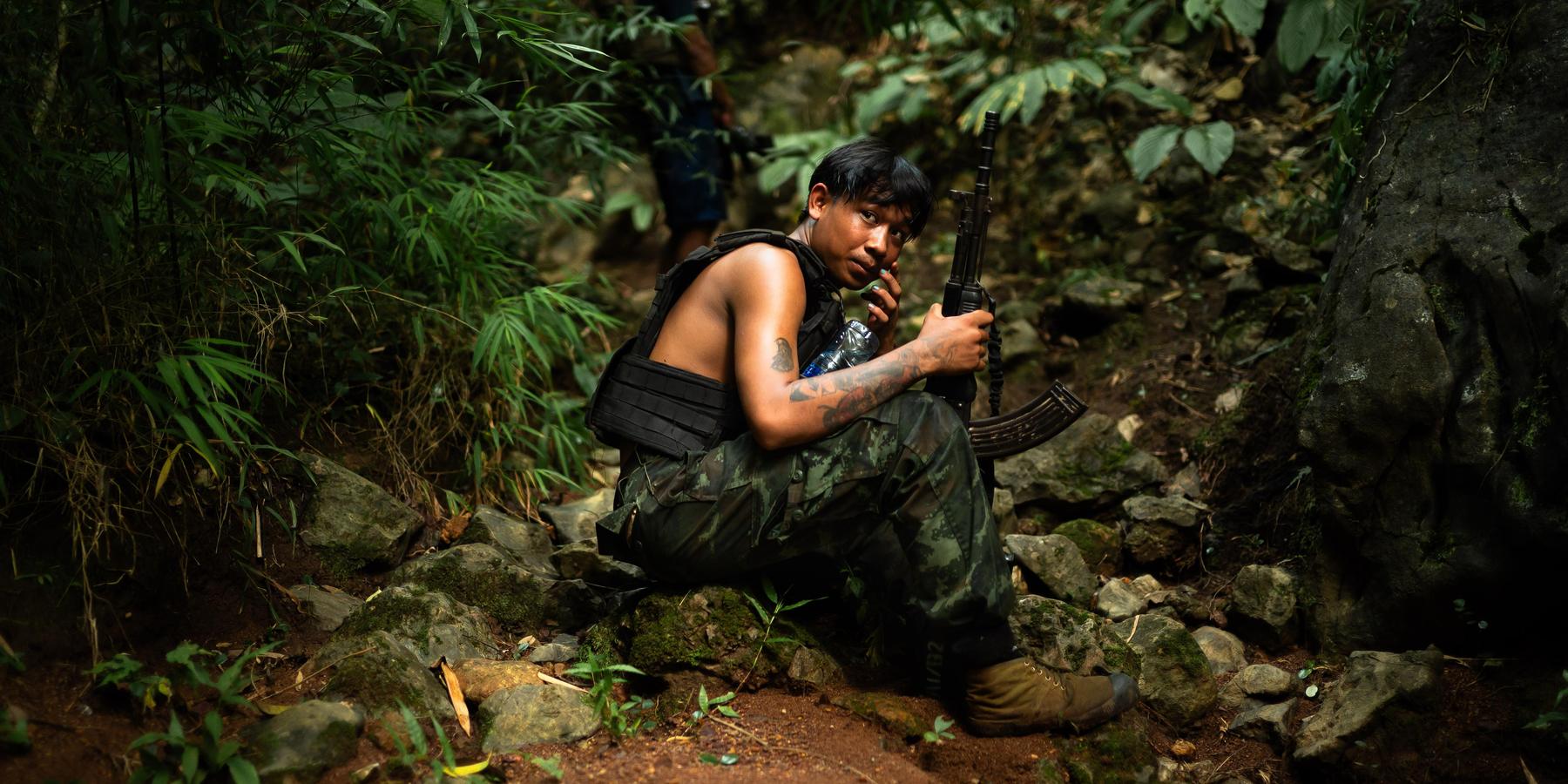 A soldier from Alpha Team 01, affiliated with the National Unity Government, rests during a reconnaissance mission