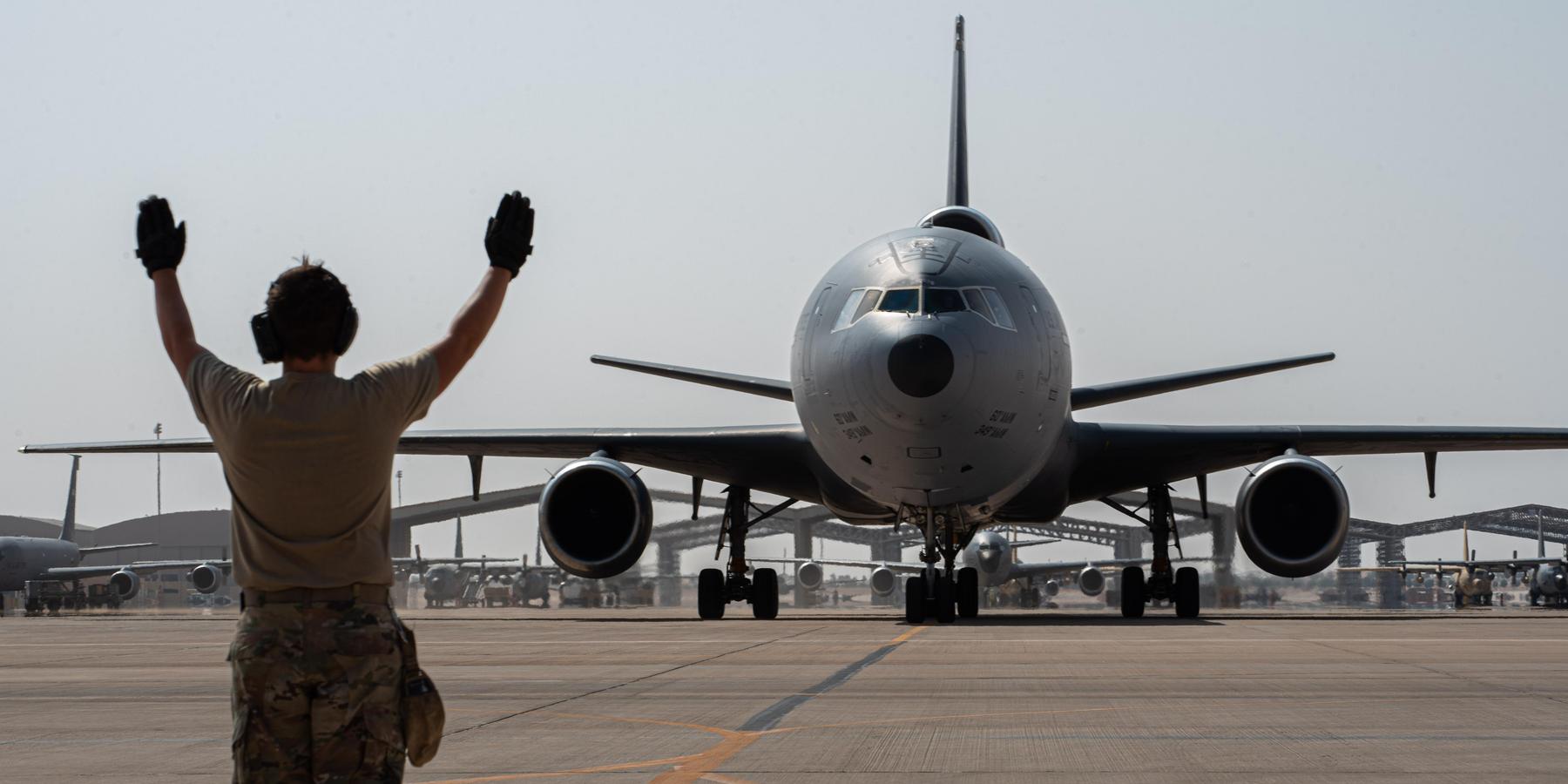 A U.S. Airman from the 378th Expeditionary Aircraft Maintenance Squadron directs a taxiing KC-10 Extender assigned to the 908th Air Refueling Squadron after the aircraft returned from the airframe's final combat sortie on Prince Sultan Air Base, Oct. 3, 2023