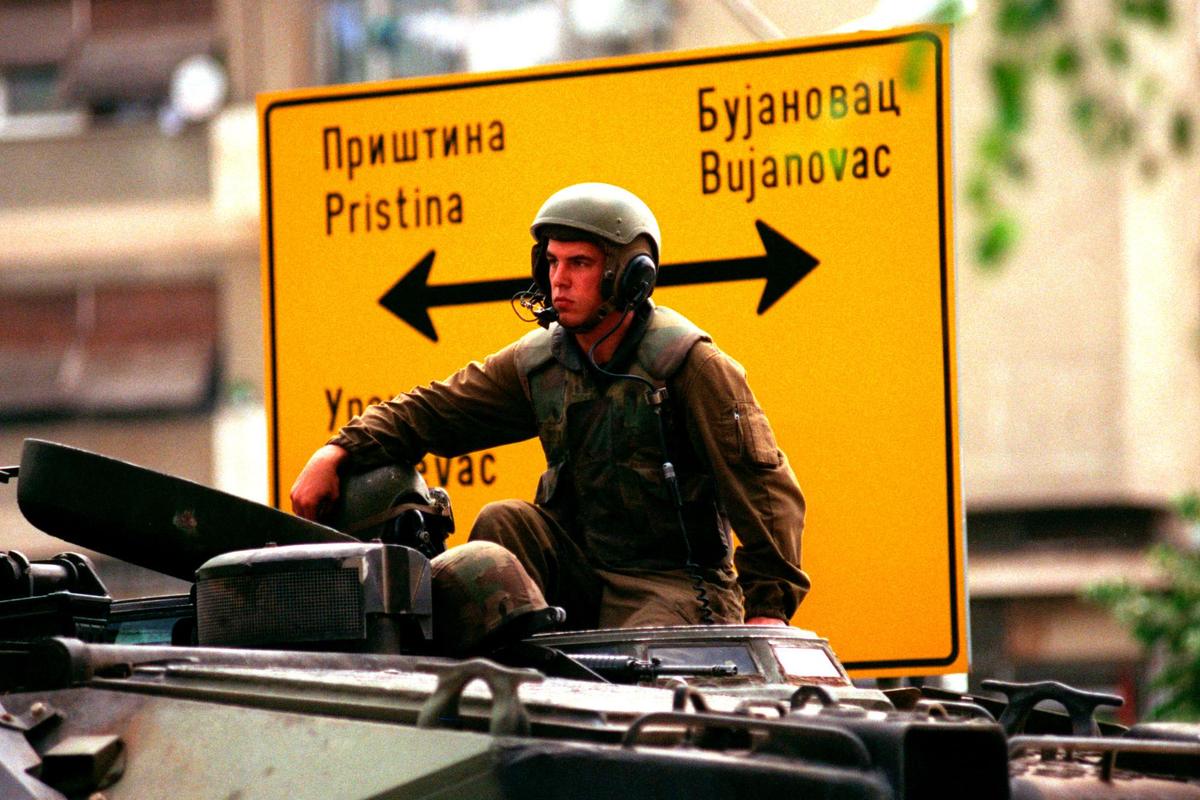 A US marine sits on an amphibious vehicle as he waits in Gnijlane, Kosovo, on July 1, 1999