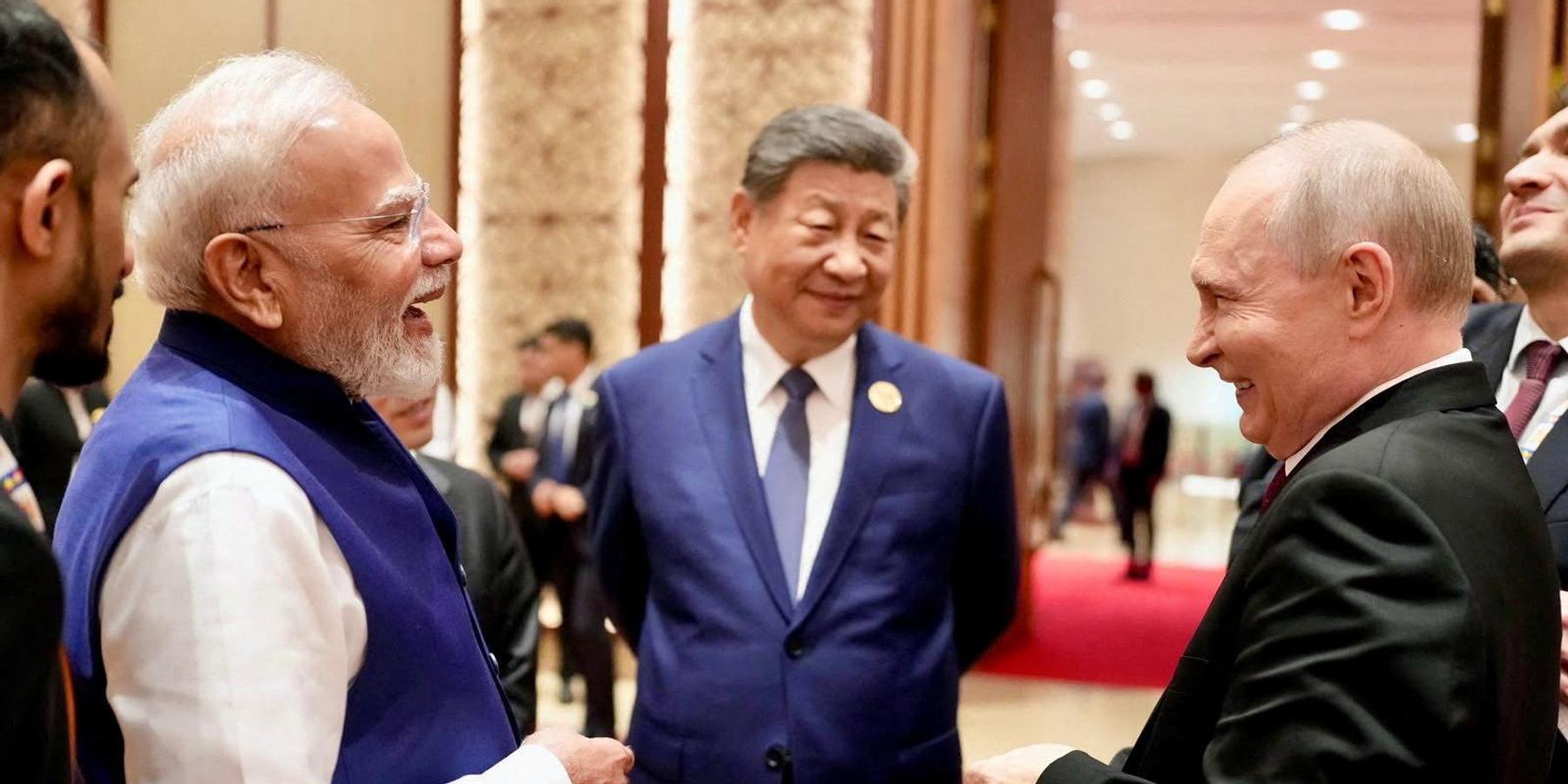India's Prime Minister Narendra Modi shares a moment with Russian President Vladimir Putin as Chinese President Xi Jinping looks on during day two of the BRICS Summit in New Delhi