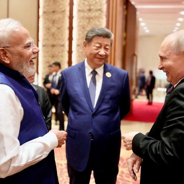 India's Prime Minister Narendra Modi shares a moment with Russian President Vladimir Putin as Chinese President Xi Jinping looks on during day two of the BRICS Summit in New Delhi