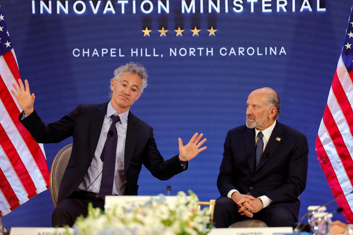 Palantir Chief Executive Officer Alex Karp gestures next to U.S. Secretary of Commerce Howard Lutnick
