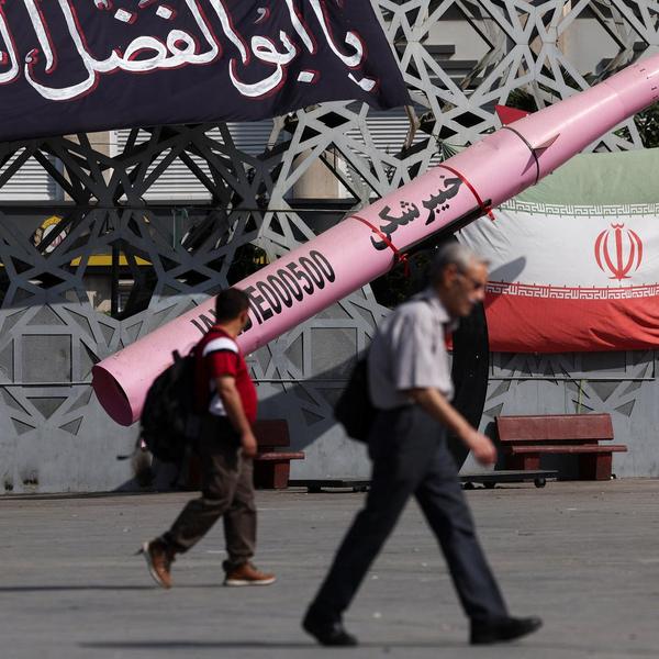People walk next to a symbolic mockup of an Iranian missile and an Iranian flag at Imam Hussein Square in Tehran, Iran, on July 12, 2026.