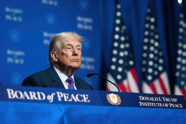 President Donald Trump sits on stage at the inaugural meeting of the Board of Peace in February 2026.