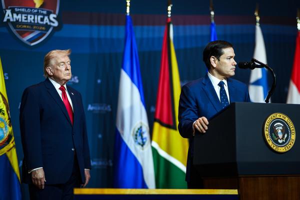 Secretary of State Marco Rubio delivers remarks during the Shield of the Americas summit as President Donald Trump looks on