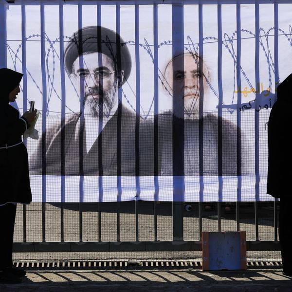 Shi'ite mourners stand in front of a banner with pictures of Hezbollah chief Naim Qassem and Iran's new Supreme Leader Mojtaba Khamenei, as they mark Ashura, the holiest day on the Shi'ite Muslim calendar, in the southern suburbs of Beirut
