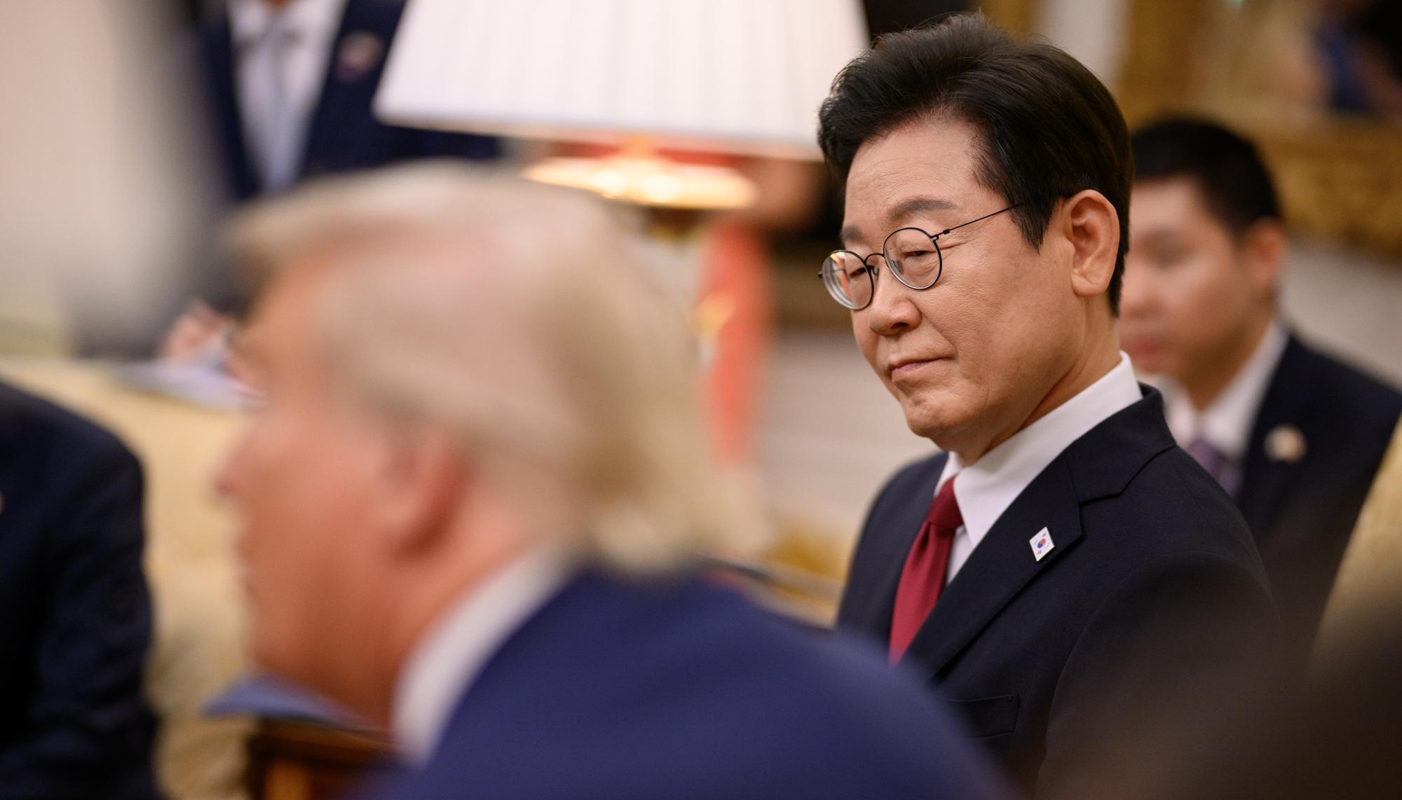 South Korean President Lee Jae-Myung looks on as President Donald Trump speaks during a meeting in the Oval Office.