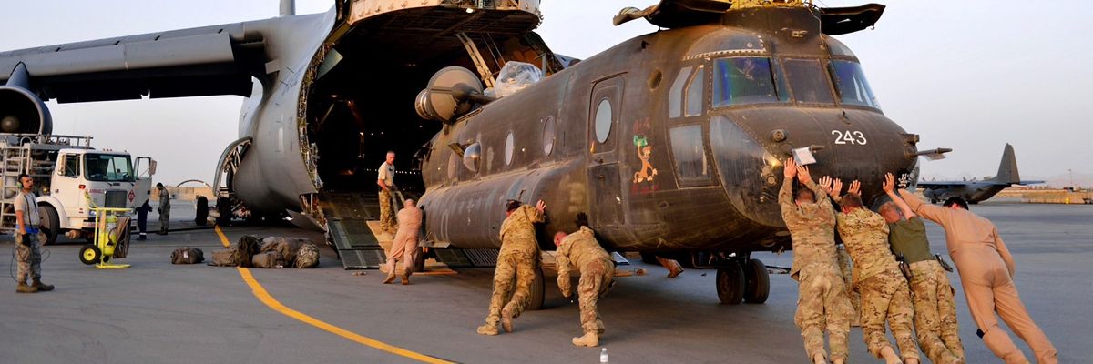 U.s._army_national_guard_soldiers_push_a_ch-47_chinook_helicopter
